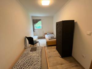 uma sala com um quarto com uma cama e uma cadeira em F4 Mouintain View Corner House with Terasse and Garden em Kőszeg