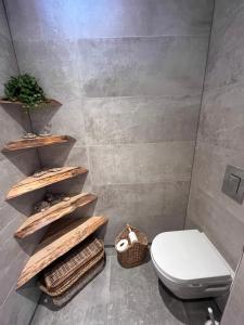 een badkamer met een toilet en houten planken bij Cosy Vacation home with large fenced garden in Bruinisse