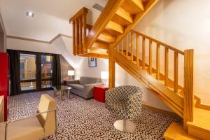 a living room with a staircase and a chair at Eurostars Royal Tanau in Baqueira-Beret