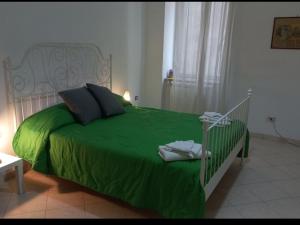 ナポリにあるcasa grecaのベッドルームに緑の掛け布団付きのベッド1台