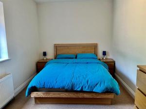 a bedroom with a bed with a blue comforter at Paultons Golf Lodge in Ower