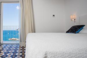 a bedroom with a bed and a view of the ocean at Hotel Marina Riviera in Amalfi