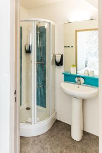 a bathroom with a sink and a shower at Hôtel Restaurant La Voile - Le Dock'er in Locmariaquer