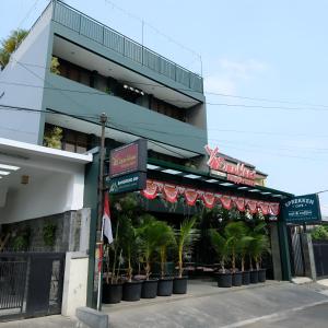 budynek z palmami przed nim w obiekcie Bangreng Inn Hotel w mieście Bandung