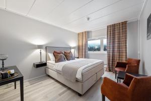 a bedroom with a bed and a desk and a chair at Spåtind Fjellhotell in Nord Torpa +91 photos