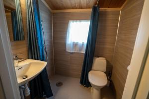 a small bathroom with a toilet and a sink at Åndalsnes Hytteutleie in Åndalsnes +17 photos
