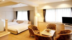um quarto de hotel com uma cama, uma mesa e cadeiras em Hotel Cypress Karuizawa em Karuizawa