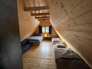 a room with two beds in a wooden ceiling at Chata 1-Padesátka in Bedřichov