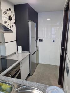 a kitchen with a refrigerator and a sink at Loft silgar in Sanxenxo +10 photos