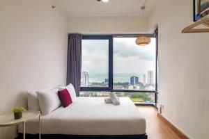 ein Schlafzimmer mit einem Bett und einem großen Fenster in der Unterkunft Tropicana 218 Macalister Penang in George Town