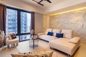 a living room with white furniture and a large window at Tropicana 218 Macalister Penang in George Town