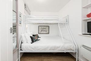 białe łóżko piętrowe w białym pokoju w obiekcie Fisherman Cottage Llanfaes near Beaumaris w mieście Llanfaes