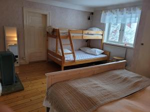 a bedroom with two bunk beds and a window at Mysigt hus utanför Järvsö in Järvsö
