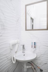 a white bathroom with a sink and a mirror at Hotel VIZA in Solotvyno
