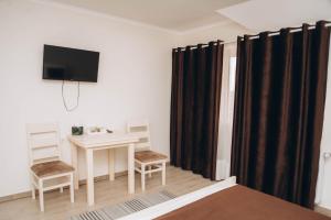 a room with a table and a tv on a wall at Hotel VIZA in Solotvyno