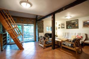 a living room with a staircase and a table and chairs at Chalupa Morávka 2 v Beskydech in Morávka