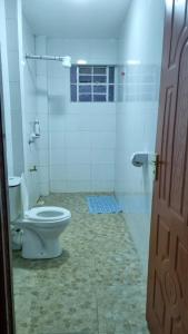 a white bathroom with a toilet and a shower at Elegant One Bedroom Garden Estate in Nairobi
