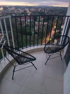 Duas cadeiras sentadas em cima de uma varanda em Elegant One Bedroom Garden Estate em Nairobi