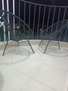 two chairs sitting on a balcony with a view at Elegant One Bedroom Garden Estate in Nairobi