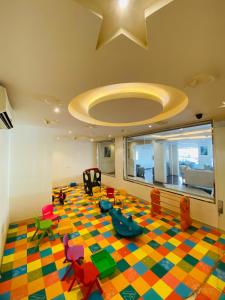 Habitación con sala de juegos y suelo colorido. en Towlan Hotel Suites 1, en Riad