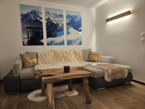 Una sala de estar con un sofá y una mesa de café. en Appartement Cosy, Vue Mont Blanc, Plein Centre, en Chamonix-Mont-Blanc