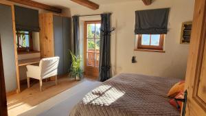 um quarto com uma cama, uma cadeira e uma janela em Chalet Nestwärme em Reith bei Kitzbühel