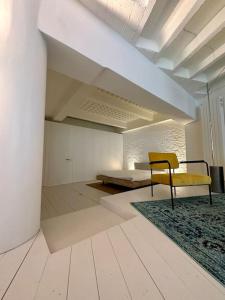 a empty room with a yellow chair and a rug at Loft industriel en duplex - The Urban Garage in Lausanne