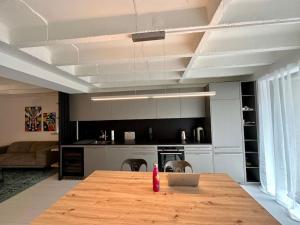 una cocina con mesa de madera y ordenador portátil. en Loft industriel en duplex - The Urban Garage, en Lausana