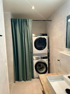 a washing machine in a bathroom with a shower curtain at Loft industriel en duplex - The Urban Garage in Lausanne