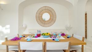 a dining room table with a bowl of fruit and a mirror at VILLA ANGA 10&1, Emma Villas in Arzachena