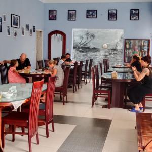 een groep mensen die aan tafel zitten in een restaurant bij The Moon Villa Hoi An in Hội An