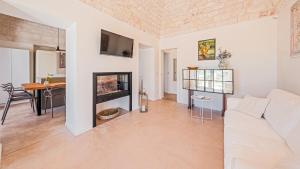 een woonkamer met een witte bank en een open haard bij BORGO DELL'AGRUMETO 8, Emma Villas in Ostuni