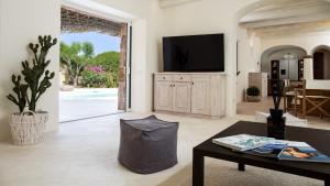 a living room with a tv and a table at VILLA ANGA 10&1, Emma Villas in Arzachena