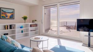 een woonkamer met een blauwe bank en een tv bij VILLA GIOIA 8, Emma Villas in Sanremo