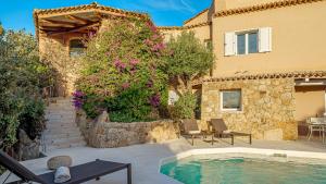 a house with a swimming pool next to a building at VILLA ANGA 10&1, Emma Villas in Arzachena