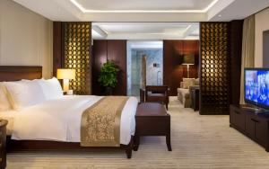 een hotelkamer met een bed en een televisie bij Jinling Hotel in Nanjing