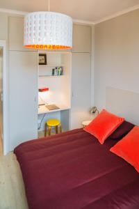 a bedroom with a bed with red sheets and a desk at Appartement 11 place d'Alliance in Nancy