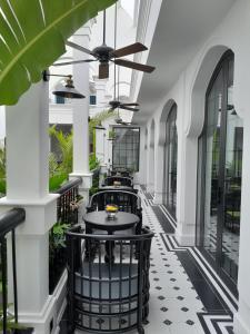 einen Innenkorridor eines Gebäudes mit schwarzen und weißen Fliesen in der Unterkunft Paul Chabot Hotel in Haiphong