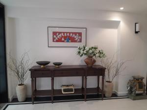 einen Tisch mit zwei Vasen und Blumen darauf in der Unterkunft Paul Chabot Hotel in Haiphong