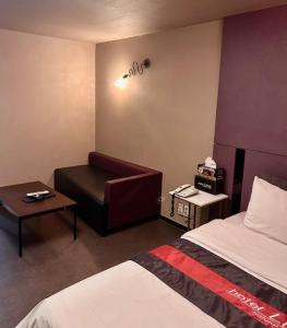 ein Hotelzimmer mit einem Bett und einem Stuhl in der Unterkunft Lime hotel in Suwon