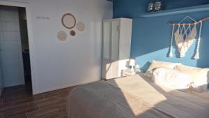 1 dormitorio con 1 cama con pared azul en Villa Contenta Canyelles, en Canyelles