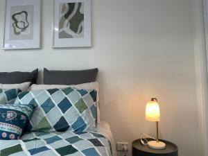 a bedroom with a bed and a lamp on a table at Luxury CBD 2 Bed Near Riverside Market Free Parking! in Christchurch