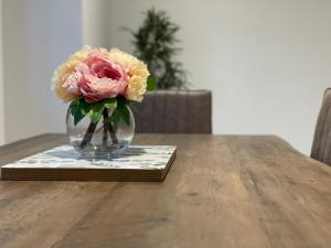 a vase of flowers sitting on a table at Luxury CBD 2 Bed Near Riverside Market Free Parking! in Christchurch