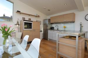 a kitchen and dining room with a glass table at Old Fire Station in Tighnabruaich