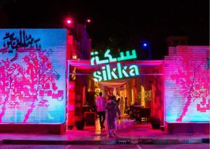 a group of people walking down a street at night at Honeycomb Capsule Hostel Near Burjuman and Sharaf dg metro in Dubai