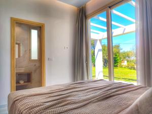 a bedroom with a bed and a large window at Villa Mavra in Planos