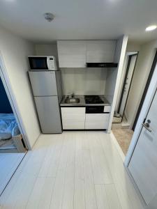 a small kitchen with a stove and a microwave at CAlMU ASAKUSA HOTEL ASAKUSA UENO IMADOZINZYA TOKYOSKYTREE HANEDA NARITA GINZA TOKYOSTATION Direct 浅草上野東京スカイツリー 成田空港羽田空港東京駅直行バス 電車便利 in Tokyo