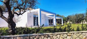 una pequeña casa blanca con una pared de piedra en Villa Mavra, en Plános