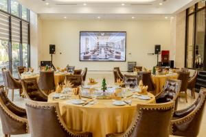 um restaurante com mesas e cadeiras e um grande ecrã em Hùng Vương Hotel em Móng Cái