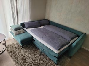a bed in a room with a blue couch at Wohnung unterm Burghalder - Direkt am Waldrand in Hauenstein